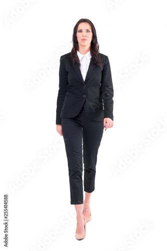 Upset serious business woman rushing and walking towards camera. Full body isolated on white background.