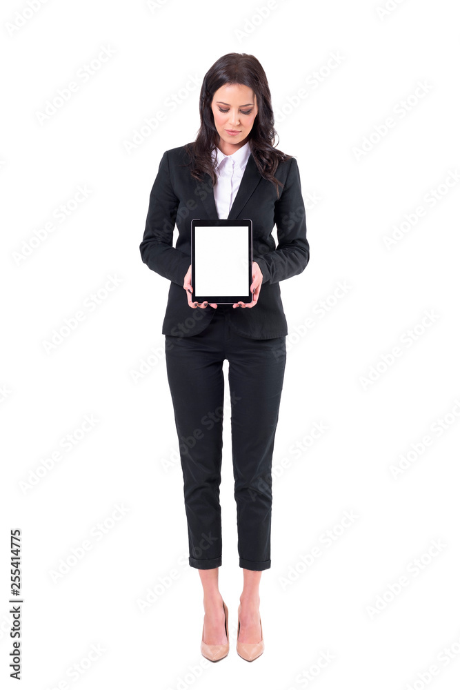 Elegant business woman looking at tablet showing blank white pad screen. Full body isolated on white background. Elegant business woman looking at tablet showing blank white pad screen. Full body isolated on white background.