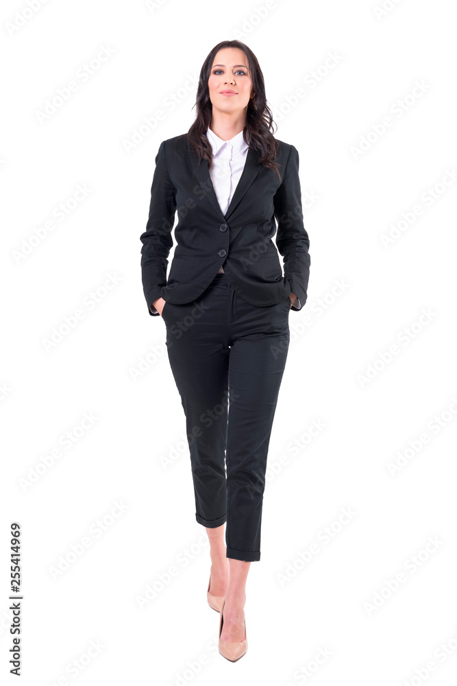 Confident successful business woman walking towards camera with hands in pockets. Full body isolated on white background. Confident successful business woman walking towards camera with hands in pockets. Full body isolated on white background.