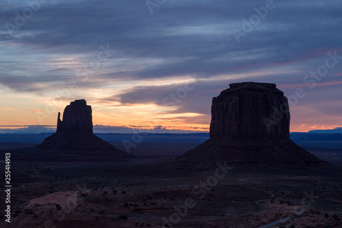 The East Mitten and Merrick buttes in Monument Valley Navajo Tribal Park at sunrise against a beautiful colourful sky with feathery clouds  Utah-Arizona border