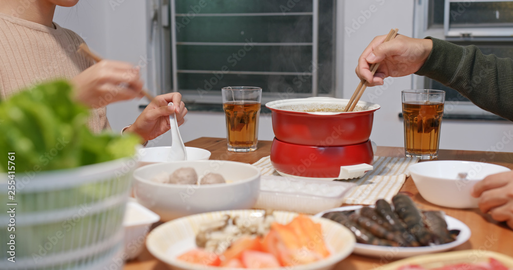 Asian couple eat hot pot together at home Asian couple eat hot pot together at home