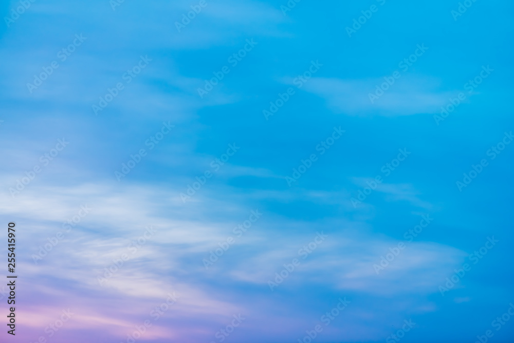 Sunset sky with pink lilac light clouds. Colorful smooth blue white sky gradient. Natural sunrise background. Amazing heaven at morning. Slightly cloudy evening atmosphere. Wonderful weather on dawn.