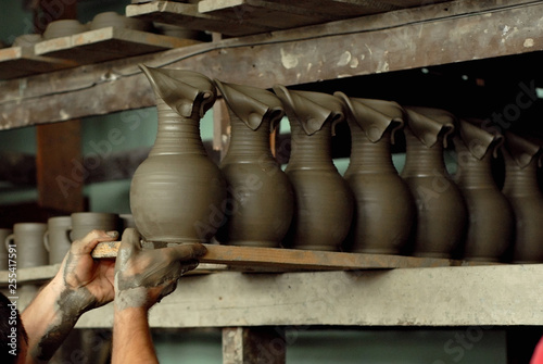 Clay pottery and ceramic products on a wooden table. Home workshop. Handmade with drawings and patterns.