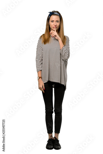 A full-length shot of a Young woman with headscarf showing a sign of silence gesture putting finger in mouth over isolated white background © luismolinero