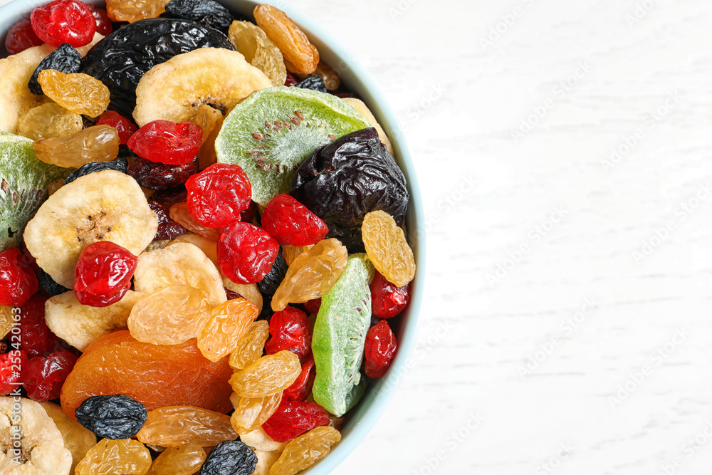 Bowl of different dried fruits on wooden background, top view with space for text. Healthy lifestyle Bowl of different dried fruits on wooden background, top view with space for text. Healthy lifestyle