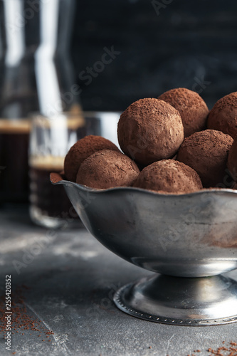 Bowl with tasty chocolate truffles on grey table
