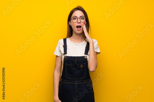 Woman over yellow wall with surprise and shocked facial expression
