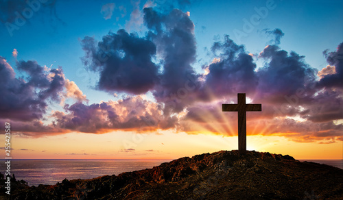 Silhouette cross on Calvary mountain - sunset background. Easter concept