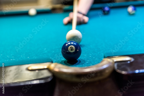 Billiard ball number two near pocket of table