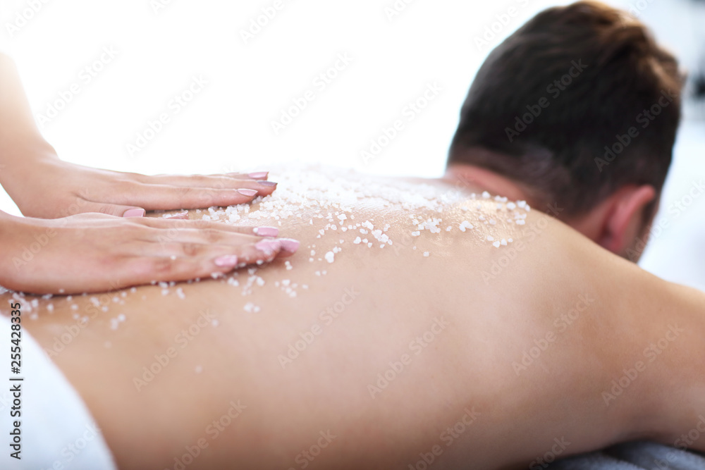 Handsome man having massage in spa salon