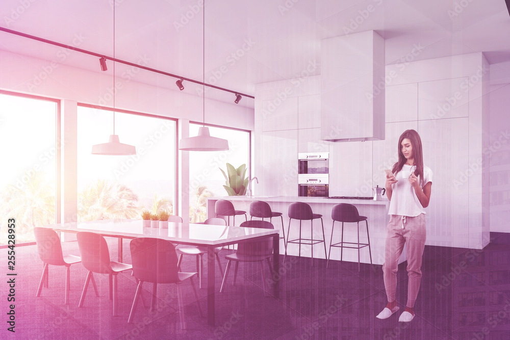 Fototapeta premium Woman in white kitchen corner with table and bar