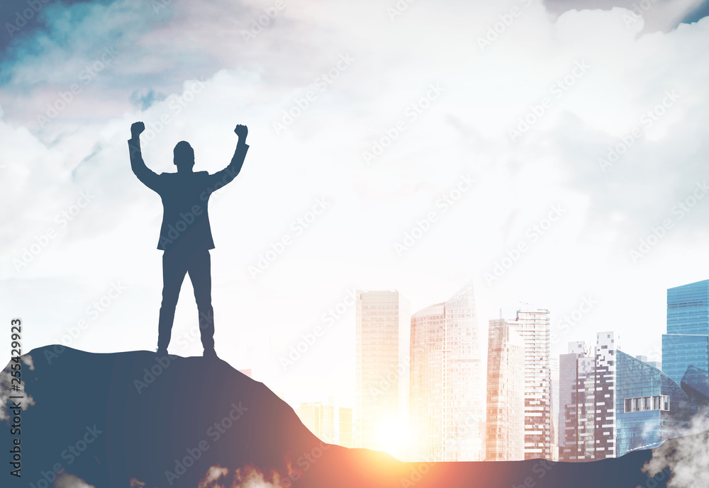 Celebrating businessman on hill in city Celebrating businessman on hill in city