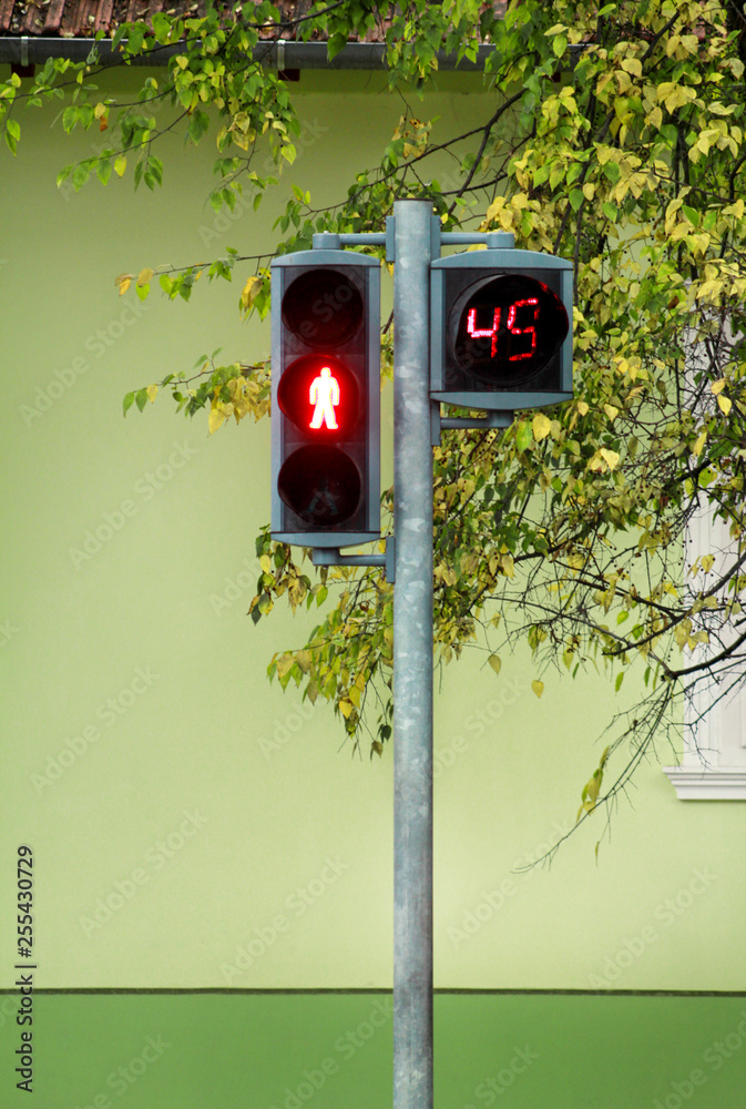 light on pedestrian crossing. Counter is counting for duration red light. Waiting start green light and crossing over pedestrian, walking on crosswalk over street and road. Stock Photo