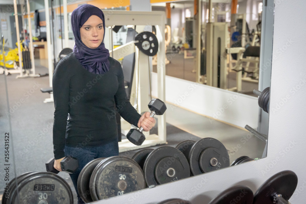 healthy muslim woman with hijab exercising in gym Stock Photo