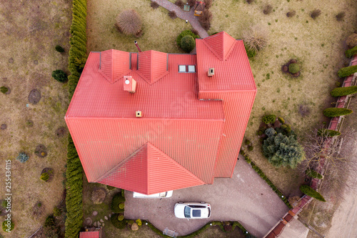 Aerial top view of new residential house cottage with shingle roof on fenced big yard on sunny day. photo