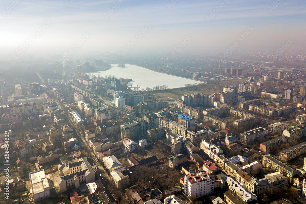 Obraz premium Aerial view of modern city urban foggy landscape on bright blue sky copy space background at dawn. Drone photography.