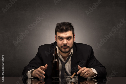 Young drunk man at his office with free dark copyspace