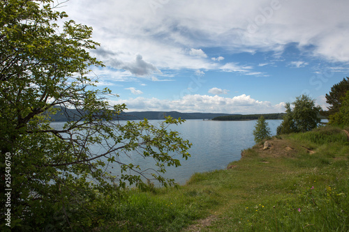 River bank summer sunny day, white clouds.