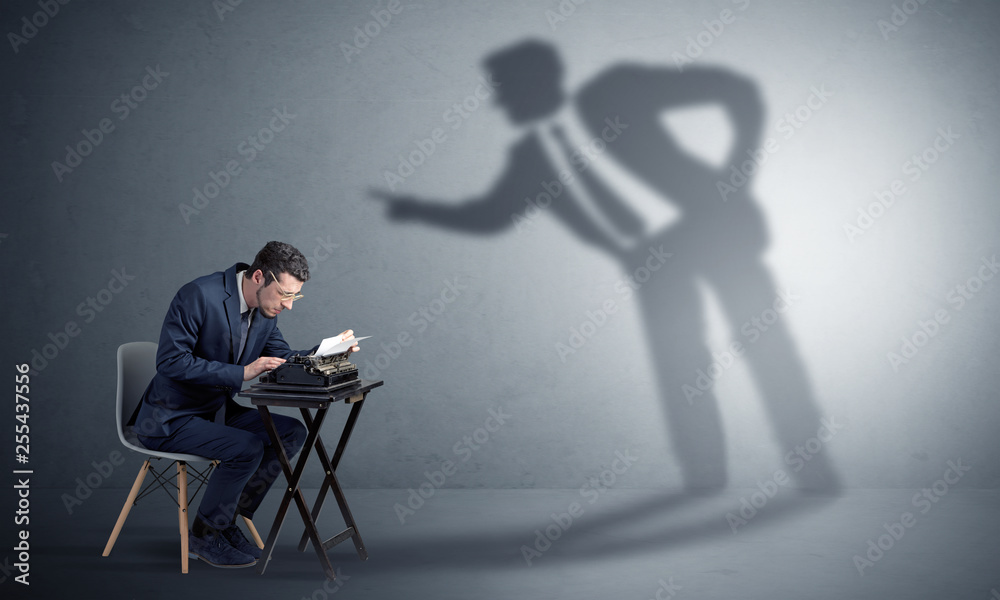Little man working and a big shadow arguing with him
Little man working and a big shadow arguing with him
