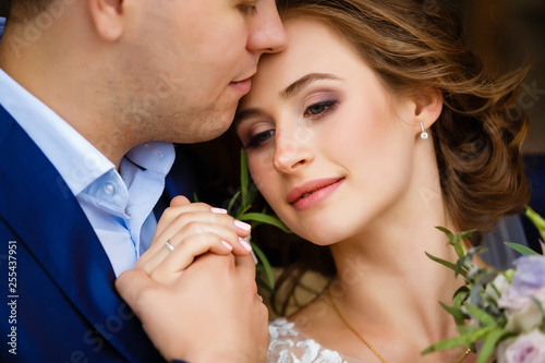 groom is kissing his bride very tender on forehead. black and white photo. photo