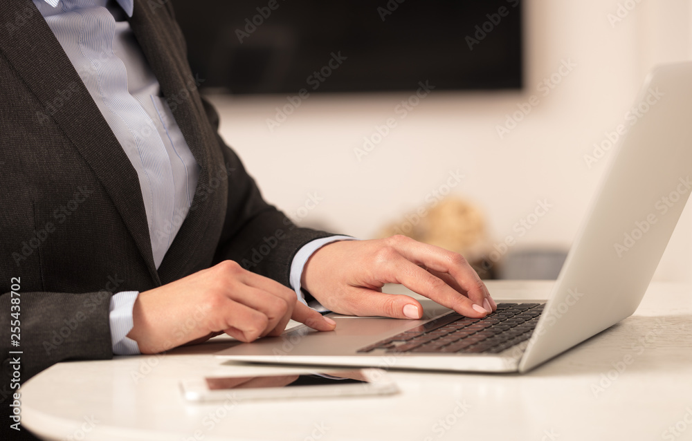 Business woman below chest working on her laptop in a cozy environment
Business woman below chest working on her laptop in a cozy environment