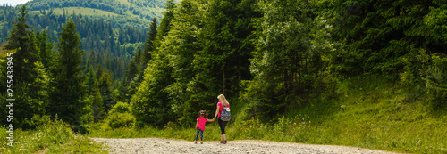 Mother and little girl walking along the mountain road