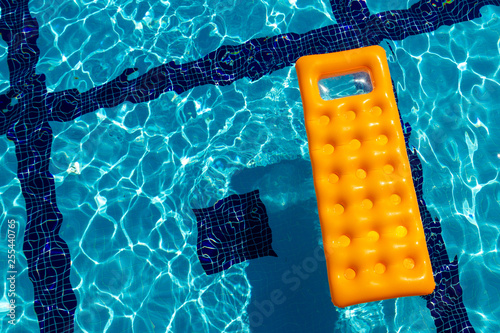 orange inflatable mattress in the pool
