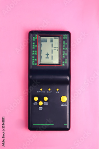 Black tetris game console on pink background retro and group 80s and 90s style with yellow buttons game from childhood
