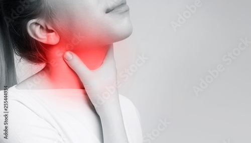Woman suffering from sore throat, touching her neck photo