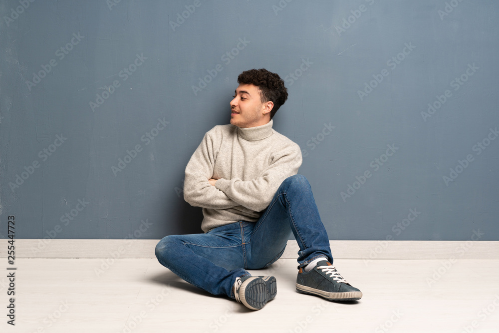 Young man sitting on the floor in lateral position