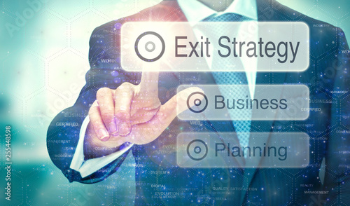 A business man selection a button on a futuristic display with a Exit Strategy concept written on it. photo