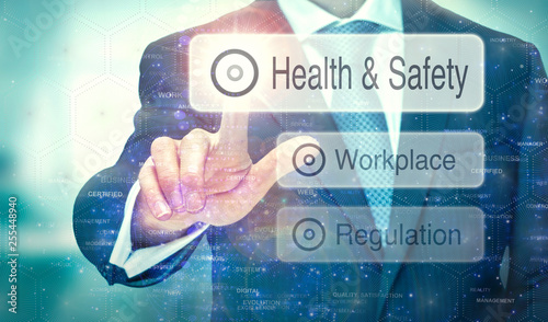 Obraz na płótnie A business man selection a button on a futuristic display with a Health and Safety concept written on it. w salonie