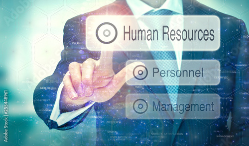 A business man selection a button on a futuristic display with a Human Resources concept written on it.