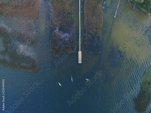 aerial shot of few children paddling a kayak on lake in the fall