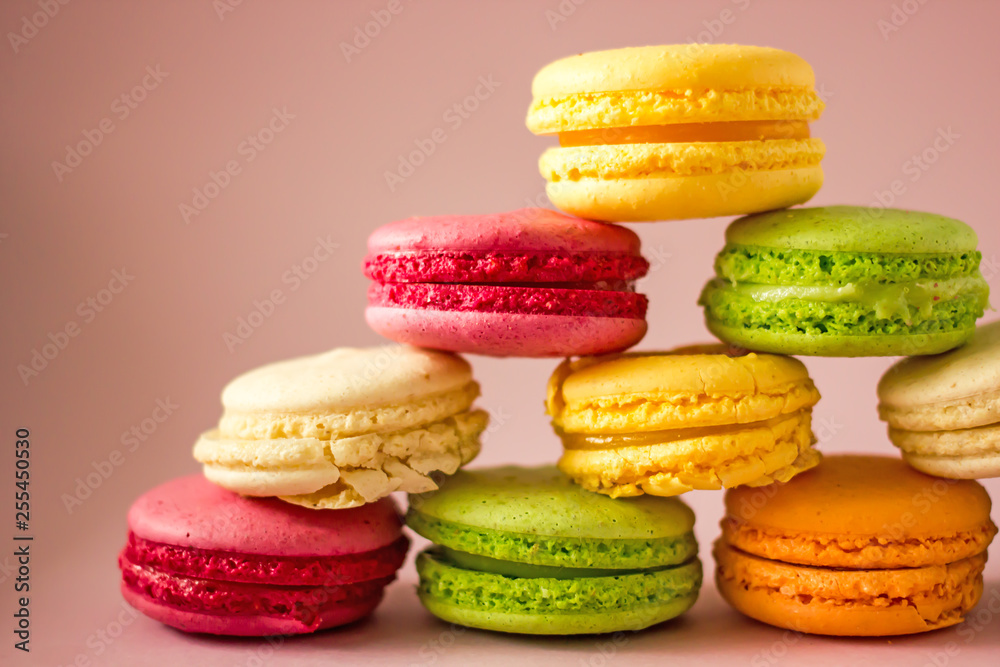 Macarons cakes of different colors on a pink background close-up. Sweet cookies from France, colorful cookies made from flour and egg whites. Confectionery background Macarons cakes of different colors on a pink background close-up. Sweet cookies from France, colorful cookies made from flour and egg whites. Confectionery background
