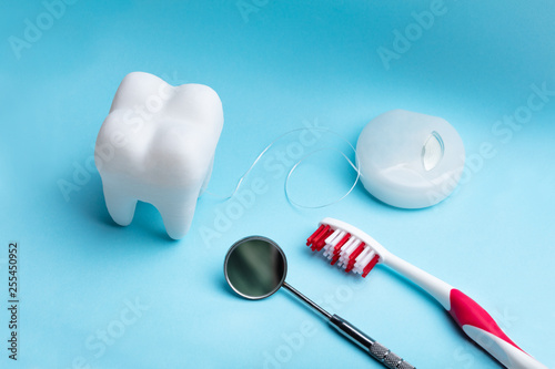 Artificial Tooth And Dental Equipment On Blue Background © Andrey Popov