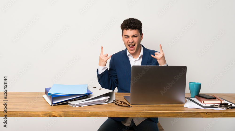 Business man in a office making rock gesture Business man in a office making rock gesture