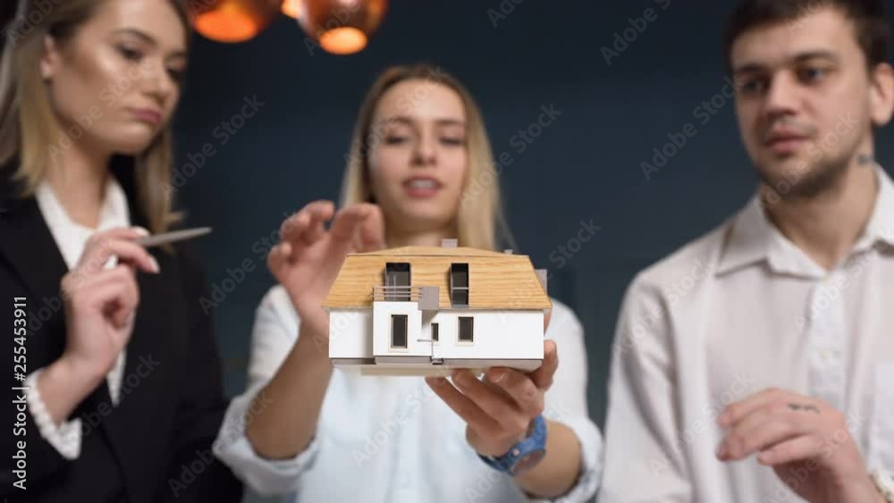 Team of young architect discussing 3d model of house. Team of young architect discussing 3d model of house.