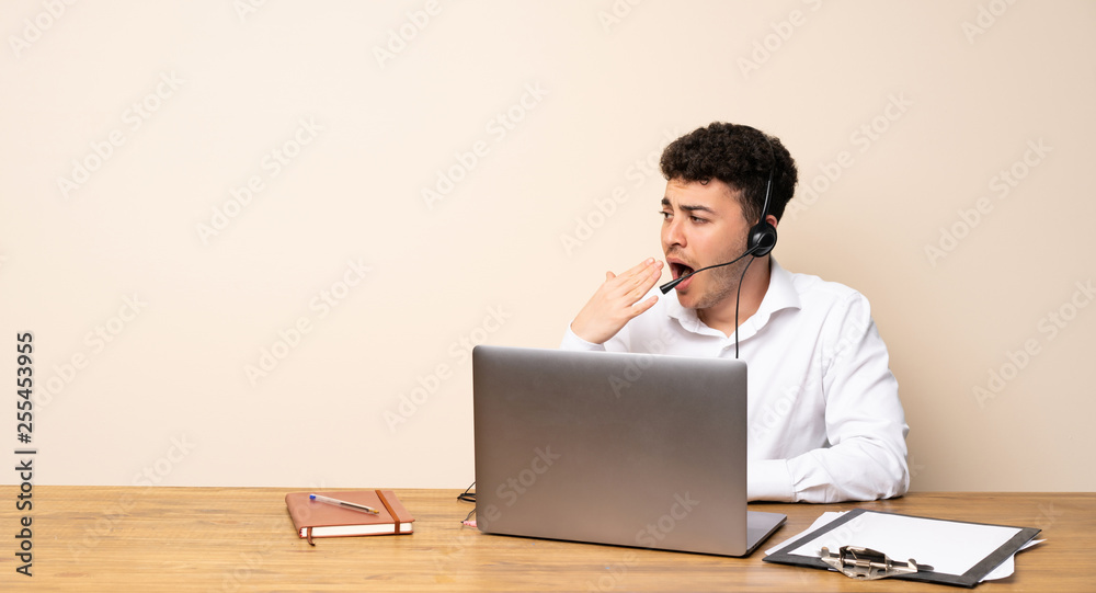 Telemarketer man yawning and covering wide open mouth with hand Telemarketer man yawning and covering wide open mouth with hand
