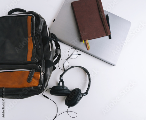 Flat lay with handsome man stuff, backpack, headphones, glasses, laptop and notebook on white background