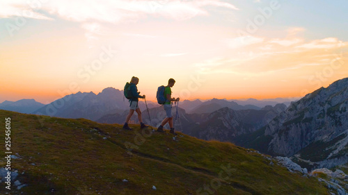 AERIAL: Carefree active woman and man enjoy a calm hike in the serene mountains.