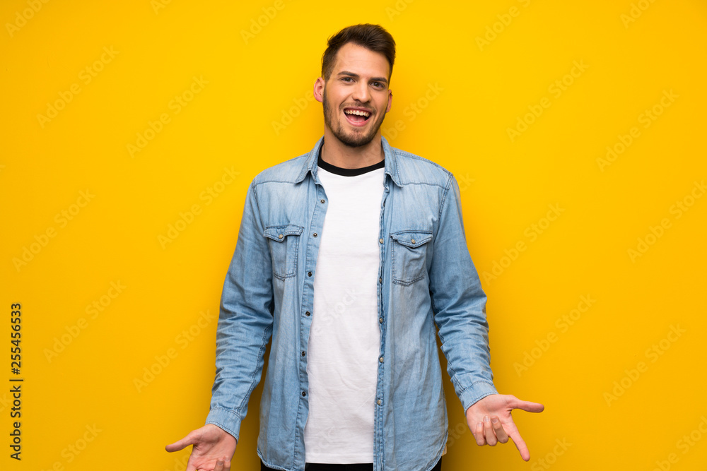 Handsome man over yellow wall smiling Handsome man over yellow wall smiling