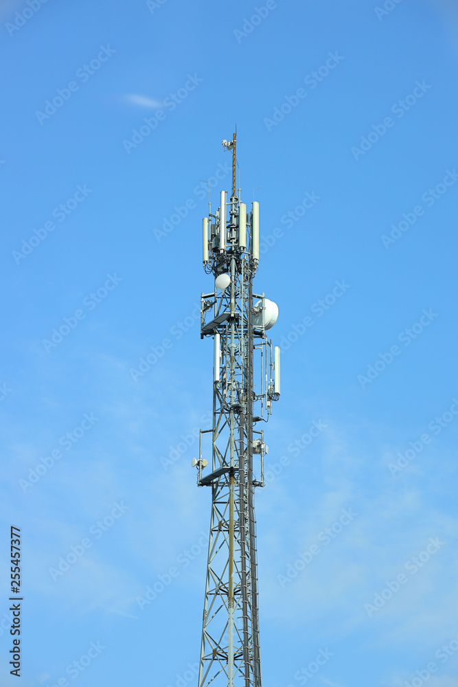 Radio tower with antennas on a blue sky background. Metal construction. Wireless network. Transmit tv radio signal. Egology of the environment. Information digitalization and high technology Radio tower with antennas on a blue sky background. Metal construction. Wireless network. Transmit tv radio signal. Egology of the environment. Information digitalization and high technology