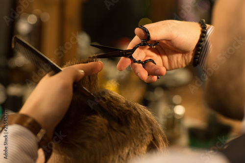 Cropped close up of the hands of a professional barber giving a haircut to his male customer hair styling hairdresser profession barbershop barbering occupation scissors masculinity hipster salon.