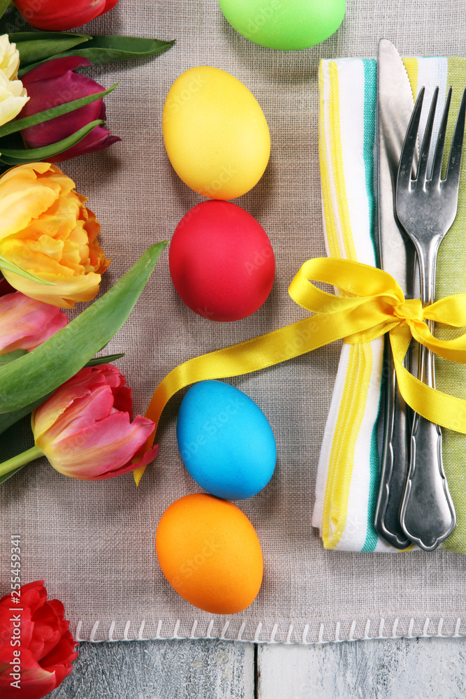 Fototapeta Festive table setting for Easter with fork, knife and tulip on table