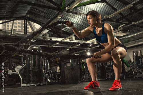 Get stronger! Female athlete working out with heavy ropes at the gym copyspace crossfit functional training fitness sport motivated determination focused success strong muscles beauty sportive concept