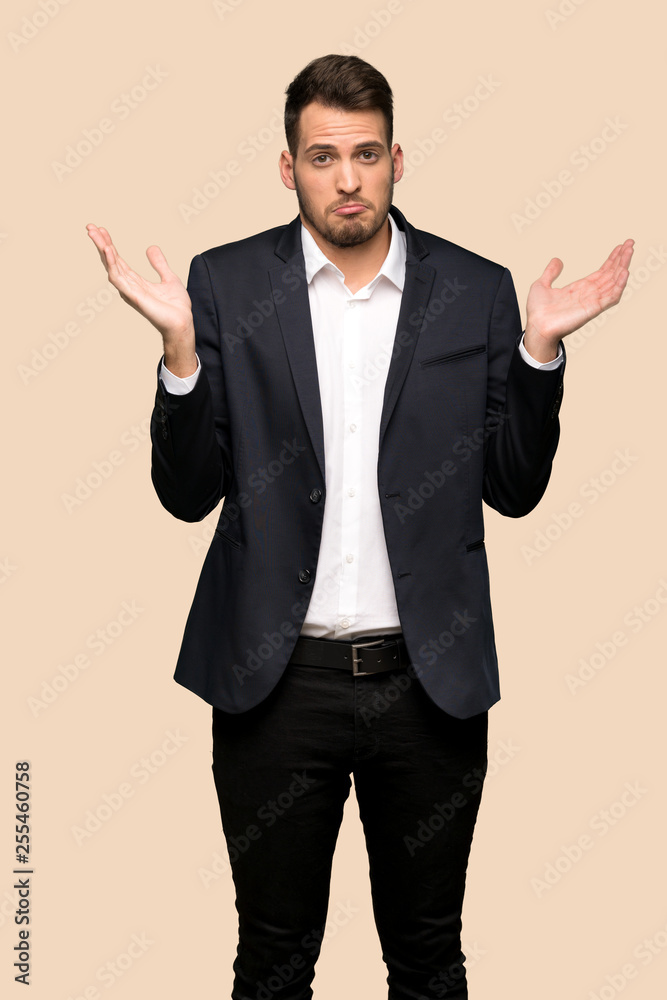 Handsome business man unhappy because not understand something over ocher background Handsome business man unhappy because not understand something over ocher background