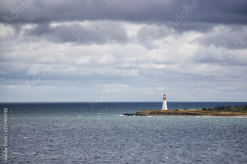 Lighthouse on the ocean coast during a cloudy day. Taken in New Victoria, Nova Scotia, Canada.