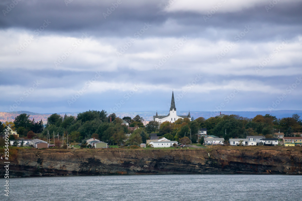 Residential homes on a rocky coast during a cloudy day. Taken in North Sydney, Nova Scotia, Canada.