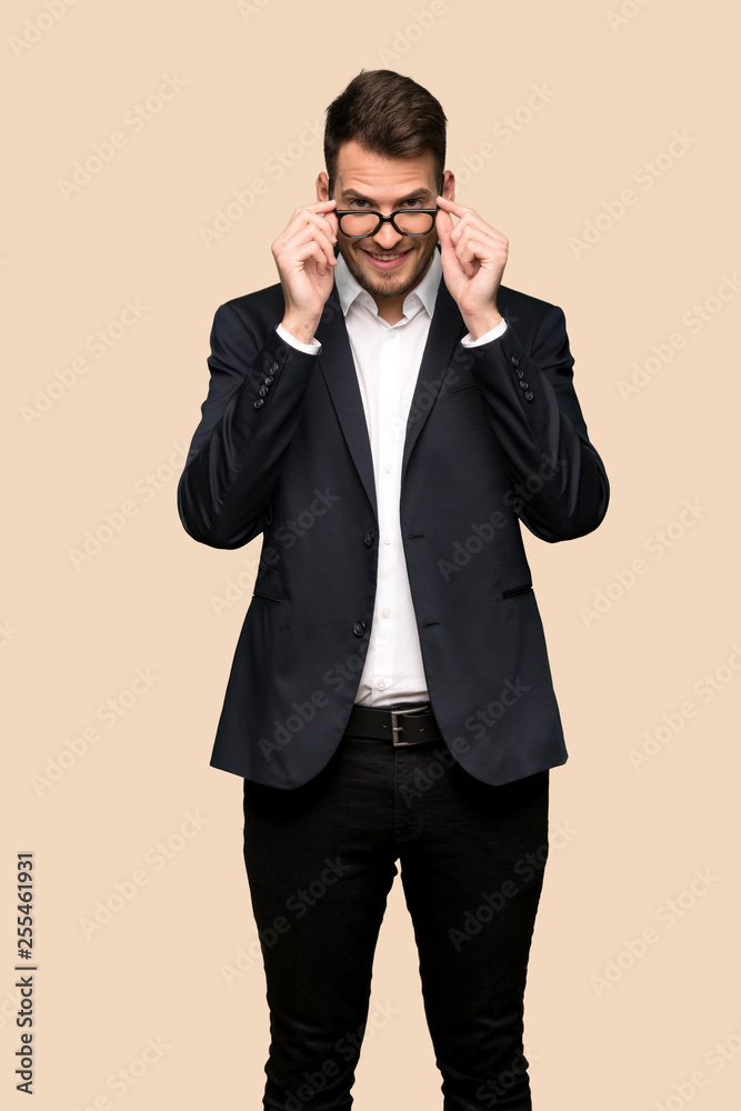 Handsome business man with glasses and surprised over ocher background Handsome business man with glasses and surprised over ocher background